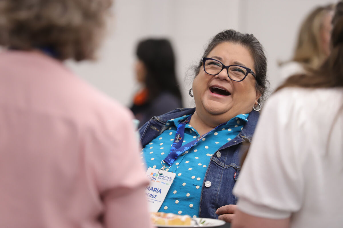 An attendee laughing with her table at the HPBExpo26 HPBA-WIN event